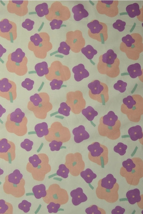 Lysegrøn bomuldspoplin med blomsterprint – fersken & lilla, metervare til erhverv (billede 1 af 3)